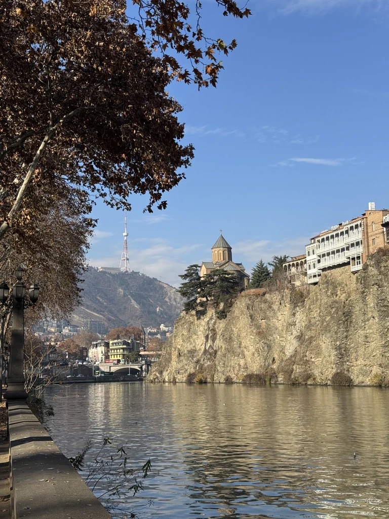 Historic buildings beside a sunlit river